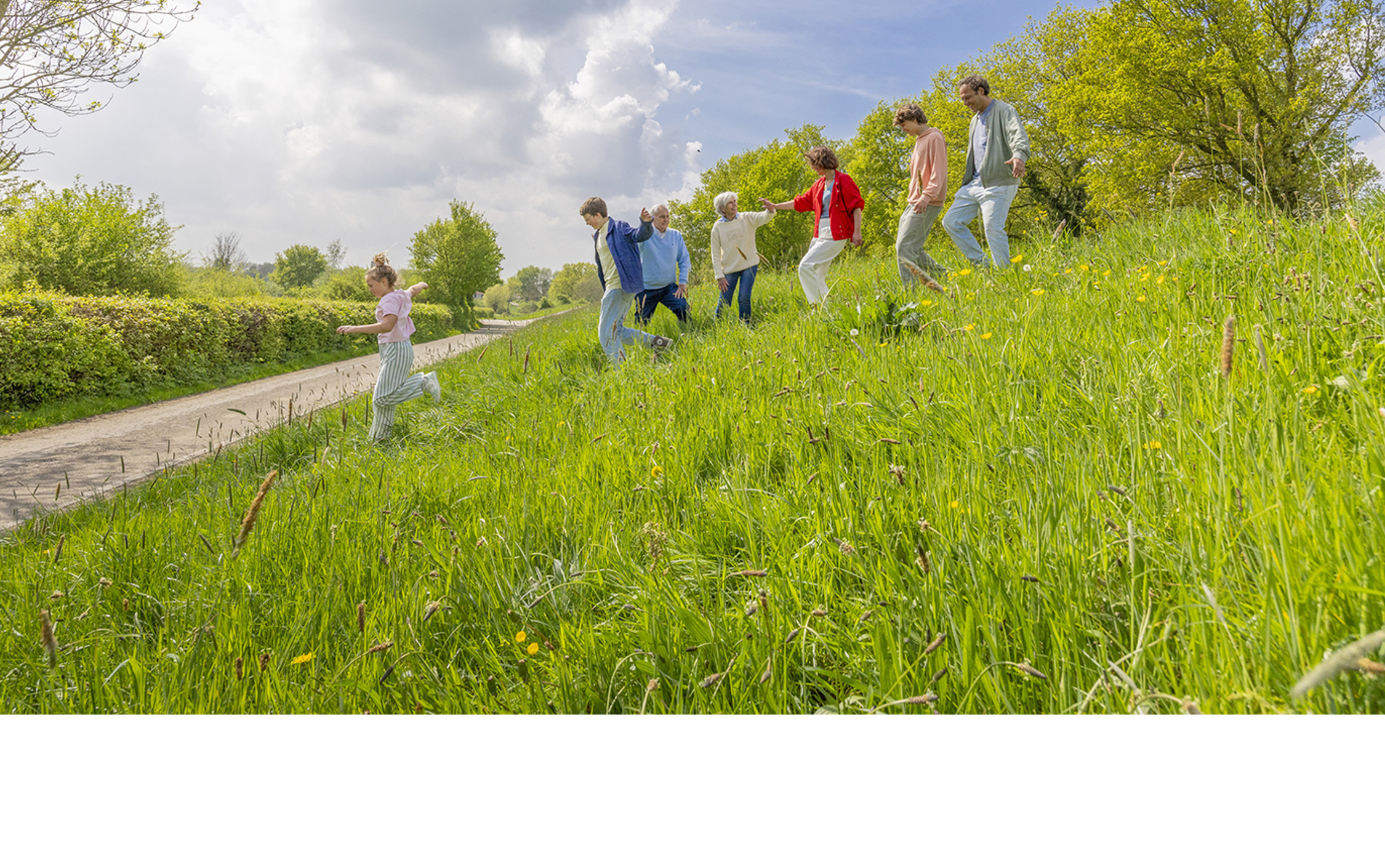 Familie samen op de dijk bij de Maas